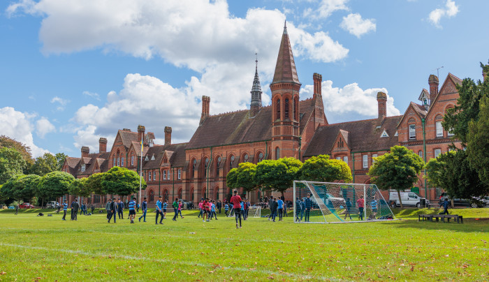 Reading School with children playing football on grass